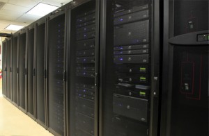 Several racks of 1u and 2u servers in black cabinets in a computer operations room.